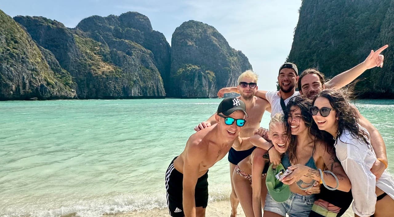 Gruppo di nomadi digitali CoLivers in spiaggia durante un'esperienza di coliving